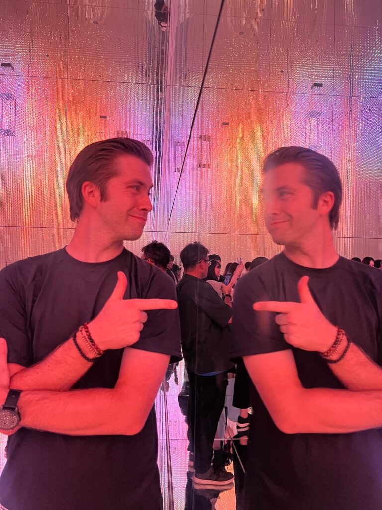 Chris pointing at himself in a mirror at teamlab Borderless in Tokyo